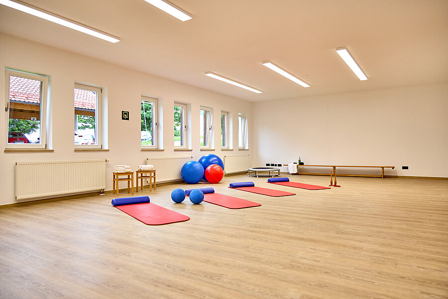 In dem hellen, großen Raum liegen Sportmatten und Pezibälle bereit.