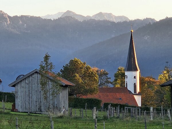 Die Saulgruber Kirche vor dem wunderschönen Panorama der Ammergauer Alpen.