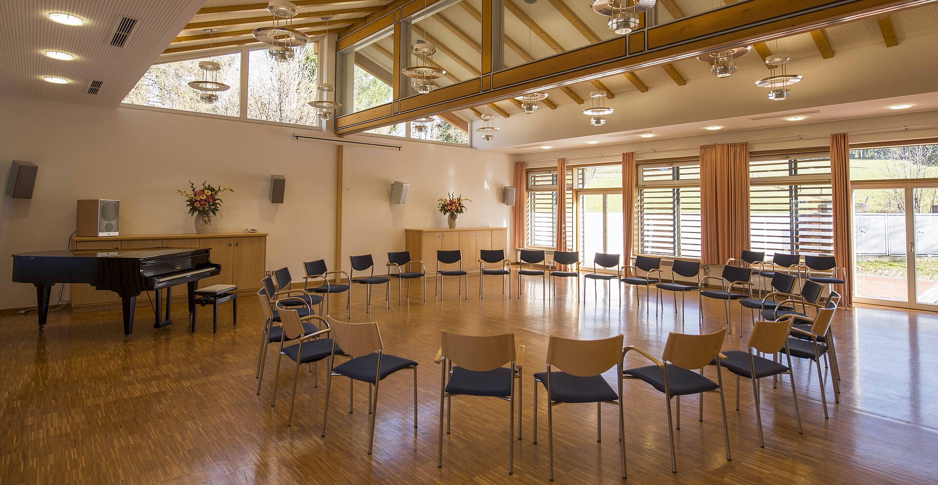 Im großen, hellen Labersaal ist ein Stuhlkreis vorbereitet. Außerdem befindet sich ein hochwertiger Flügel im Raum.