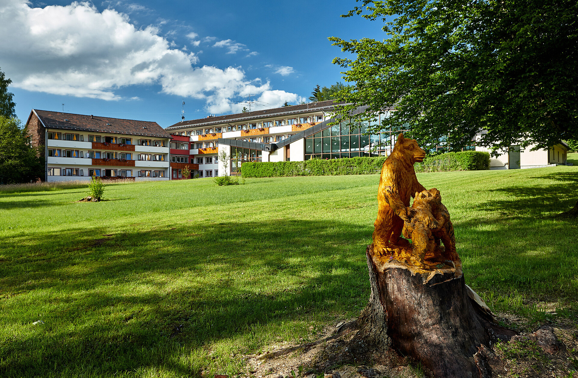 Das Hotel vom Park ausgesehen und ein geschnitztes Bärenpärchen.