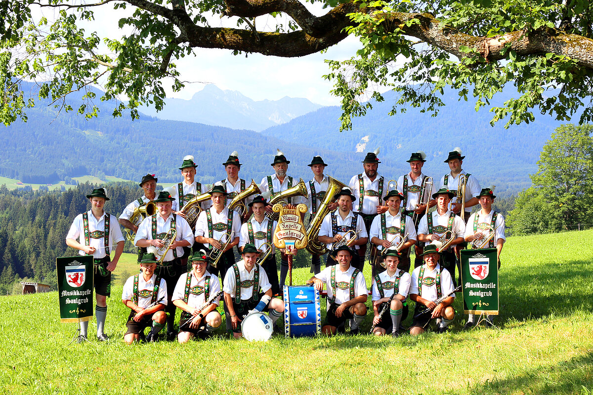 Gruppenbild der heimischen Musikkapelle in Tracht und mit Instrumenten auf dem idyllischen Wetzsteinrücken mit Bergpanorama 