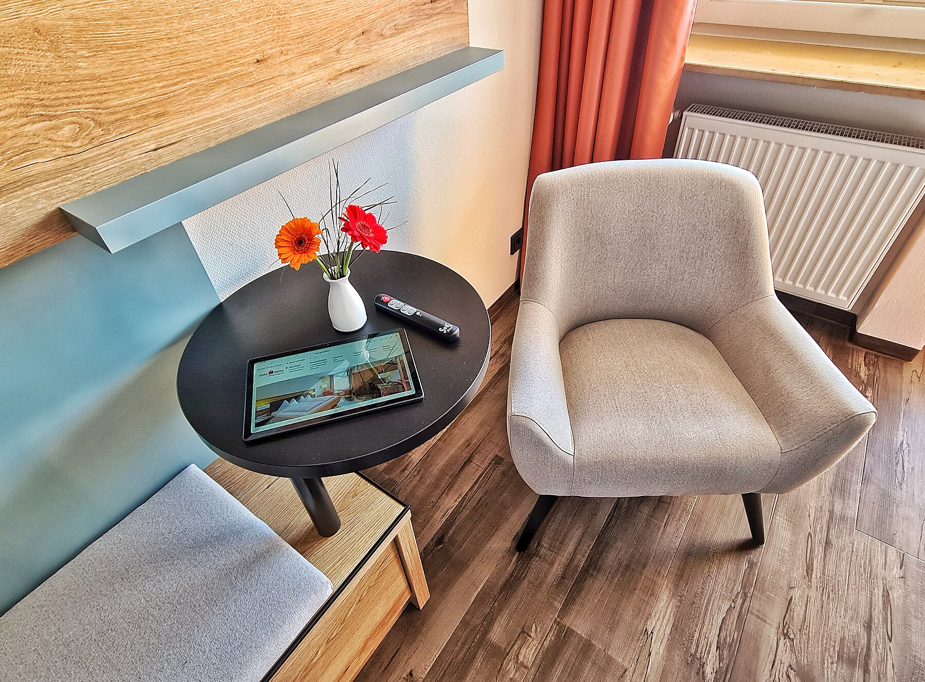 Detailaufnahme - Gemütlicher heller Sessel und rundes Ablagetischchen