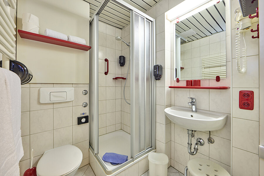 Helles Badezimmer mit kontrastreichen Ablagen.