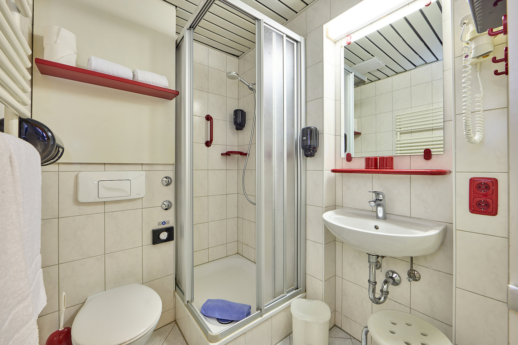 Helles Badezimmer mit kontrastreichen Ablagen.