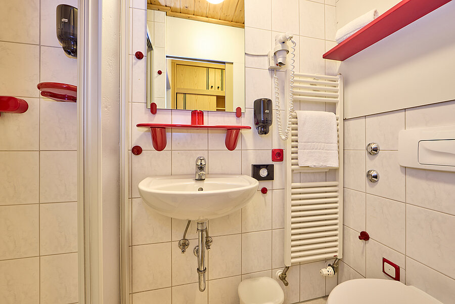 Im vollausgestatteten Bad gibt es farblich kontrastreiche Ablagen.