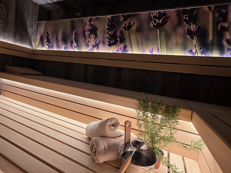 Die neue, großzügige Sauna mit hübscher floraler Wandgestaltung lädt zum Verweilen ein