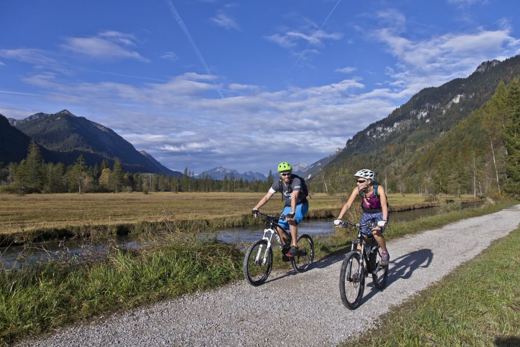Zwei Radfahrer fahren am Fluss in den Ammergauer Alpen