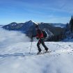 Eine Frau überquert eine schneebedeckte Fläche mit Ski