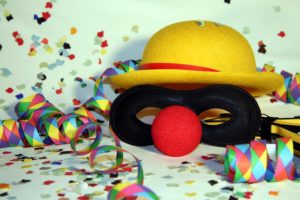 Faschingsmaske mit roter Nase mit Konfetti und Luftschlangen