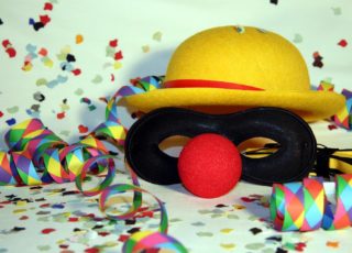 Faschingsmaske mit roter Nase mit Konfetti und Luftschlangen