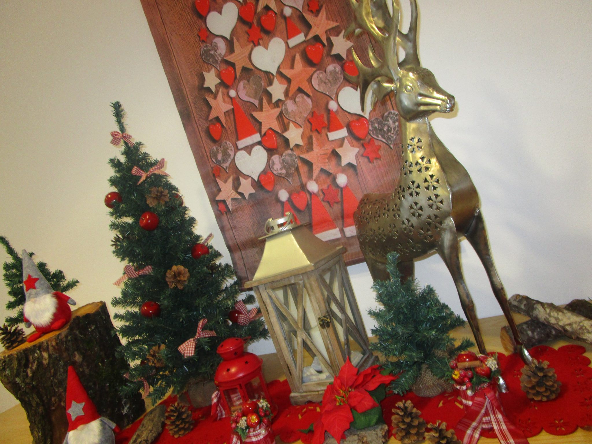 Weihnachtliche Dekoration mit silbernen Hirsch, Laternen, Naturmaterialien und Tannenbäumen