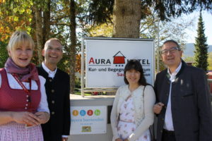 Gruppenbild vor dem Hotel-Logo des AURA-Hotels
