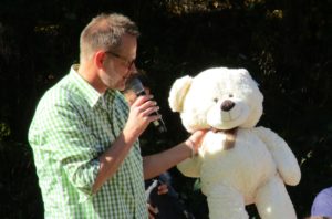 Chris Baumann überreicht einen Teddybär aus der Tombola