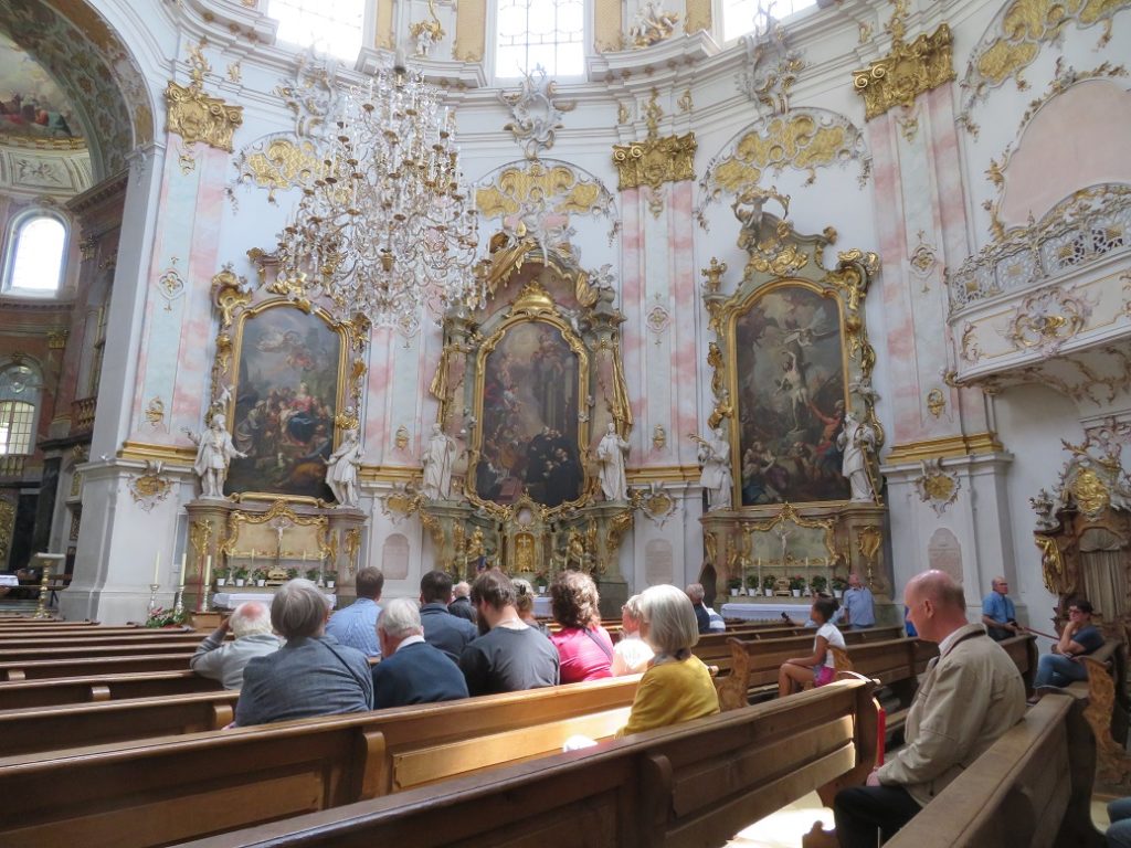 Die Besucher lauschen gespannt den Erklärungen des Paters in der Ettaler Basilika