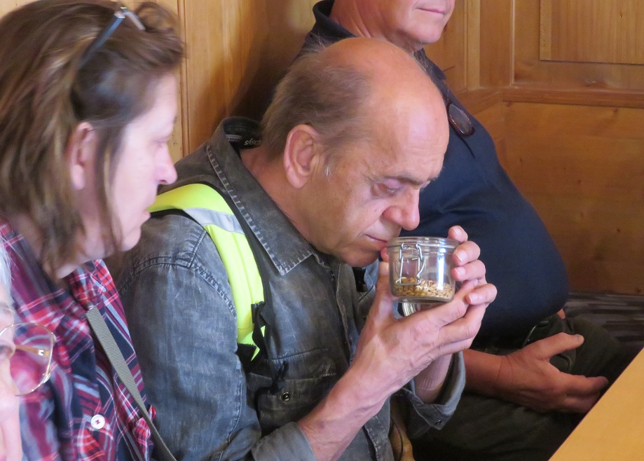 Ein blinder Gast riecht an einem Glas mit getrockneten Kräutern