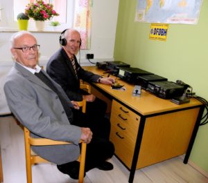 Zwei Herren sitzen in der Funkbude an einem Funkgerät