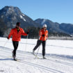 Eine Frau und ein Mann beim Langlaufen in Winterlandschaft