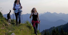 Zwei Frauen mit Hund wandern im Gebirge