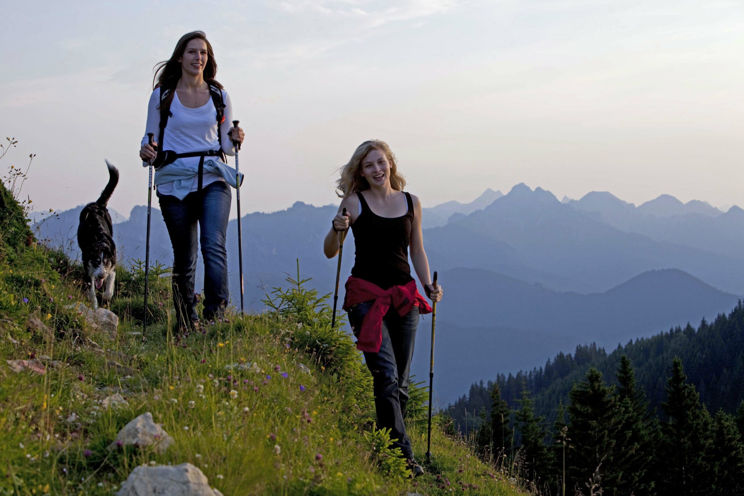 Zwei Frauen mit Hund wandern im Gebirge