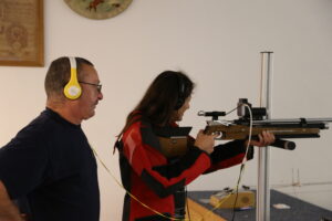 Eine Teilnehmerin justiert das Gewehr am Schießstand, unterstützt wird sie von einem Vereinsmitglied der Saulgruber Schützen.