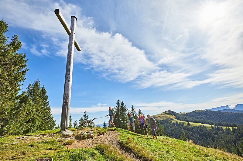 Wanderer beim Gipfelkreuz des mittleren Hörnles