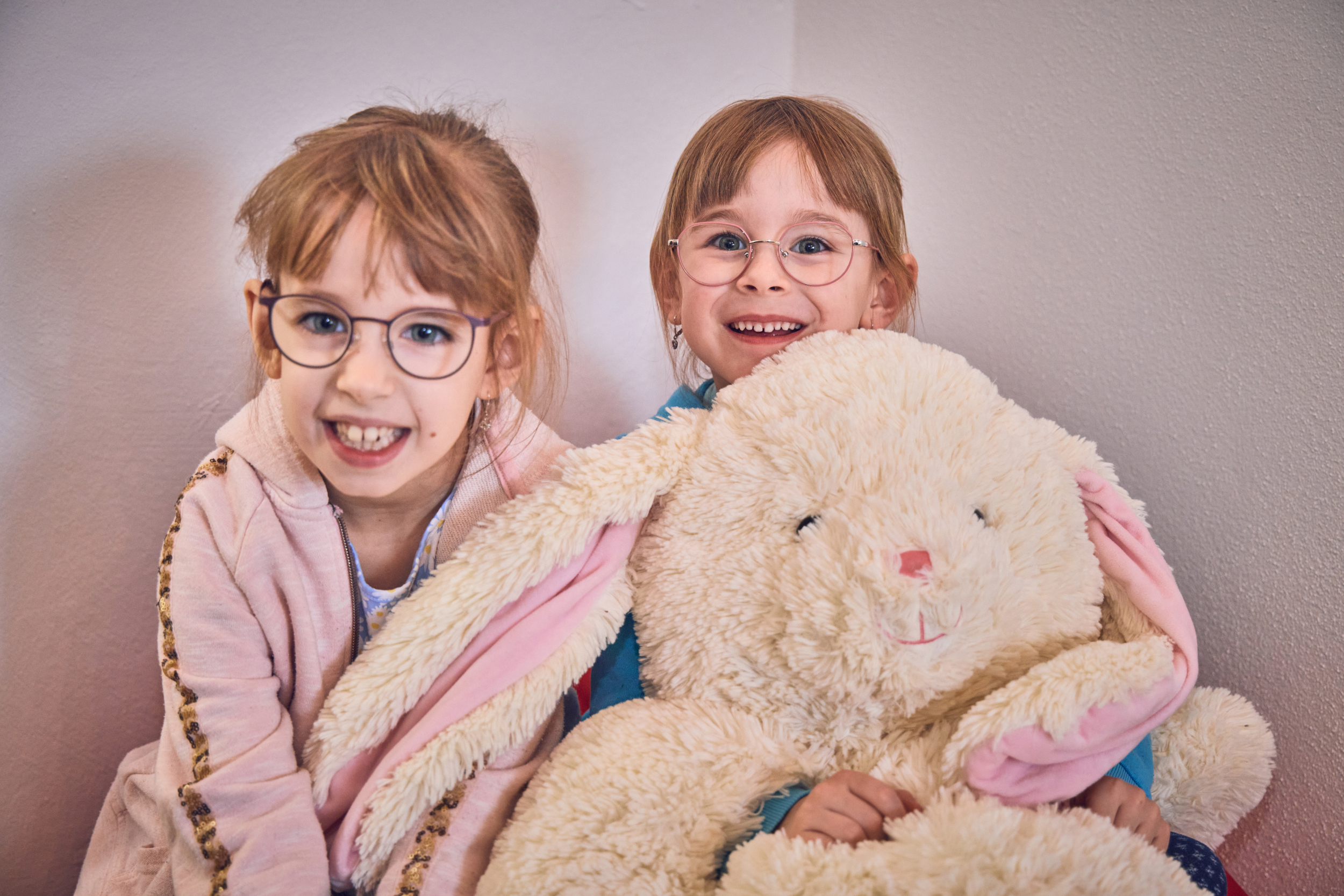 Zwei Mädchen kuscheln mit einem riesigen Plüschosterhasen